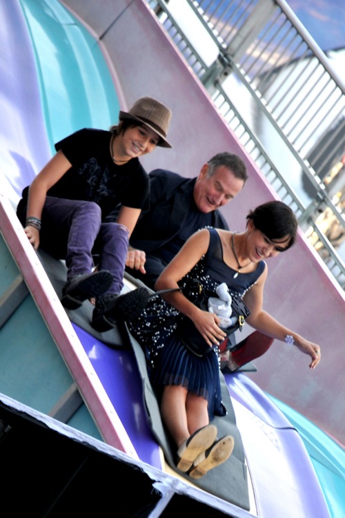 Robin Williams rides down a slide with his kids Cody and Zelda at the "Happy Feet Two" Premiere at the Grauman's Chinese Theater